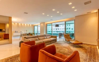 Sala de estar ampla com sofá de couro, poltronas em veludo e tapete persa