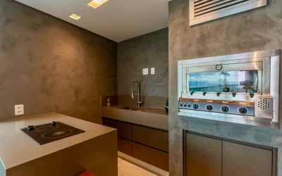 Cozinha gourmet em cimento queimado com cooktop indução e churrasqueira embutida