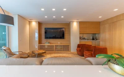 Home theater com painel de TV, bar integrado e poltronas em veludo