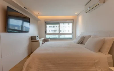 Suíte com cama king, TV de tela grande, ar-condicionado split e vista da cidade