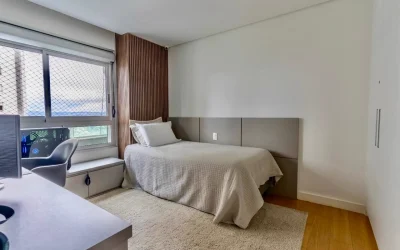 Quarto de solteiro com cama, escrivaninha planejada e vista panorâmica