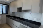Cozinha planejada gourmet com bancada preta e mármore branco — Apartamento Aldea Vale do Sereno
