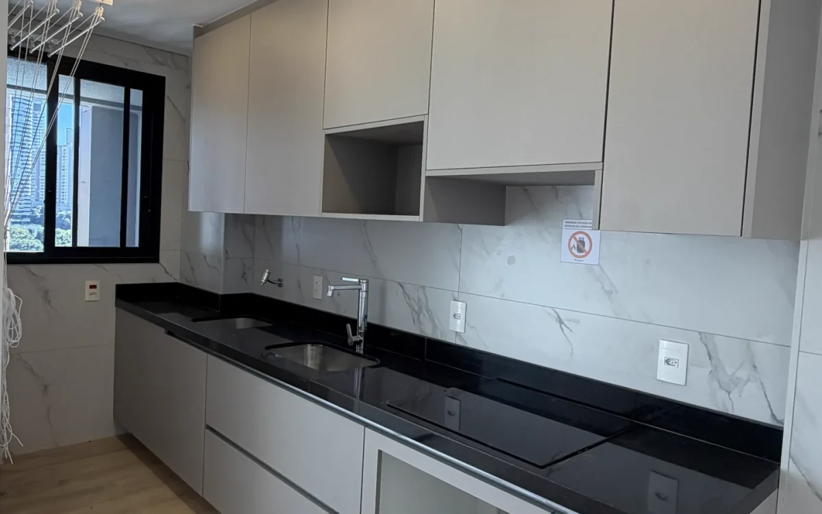 Cozinha planejada gourmet com bancada preta e mármore branco — Apartamento Aldea Vale do Sereno